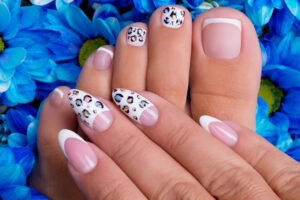 woman's nails of hands and legs with french manicure
